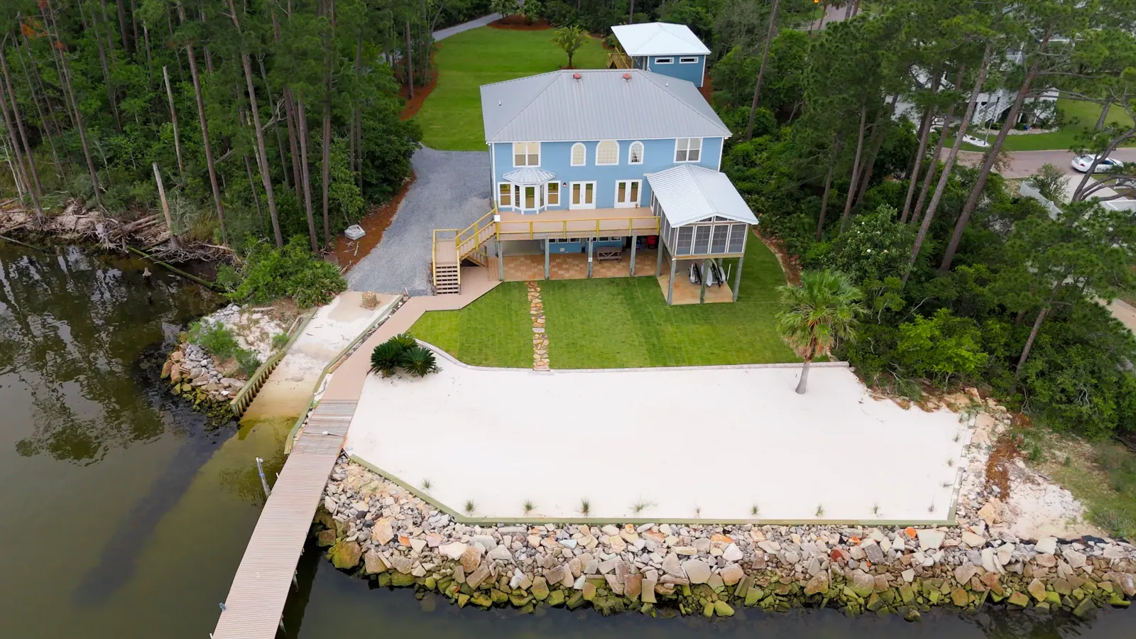 Aerial view of a finished bay-front lawn with fresh sod and crisp mow lines at a Gulf Shores, Alabama property