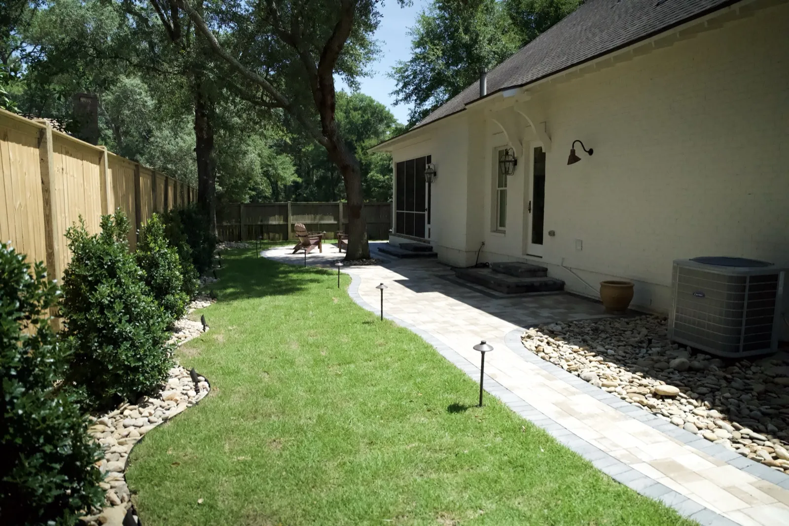 Same Point Clear backyard finished with paver walkway, fresh sod, path lighting and river-rock beds